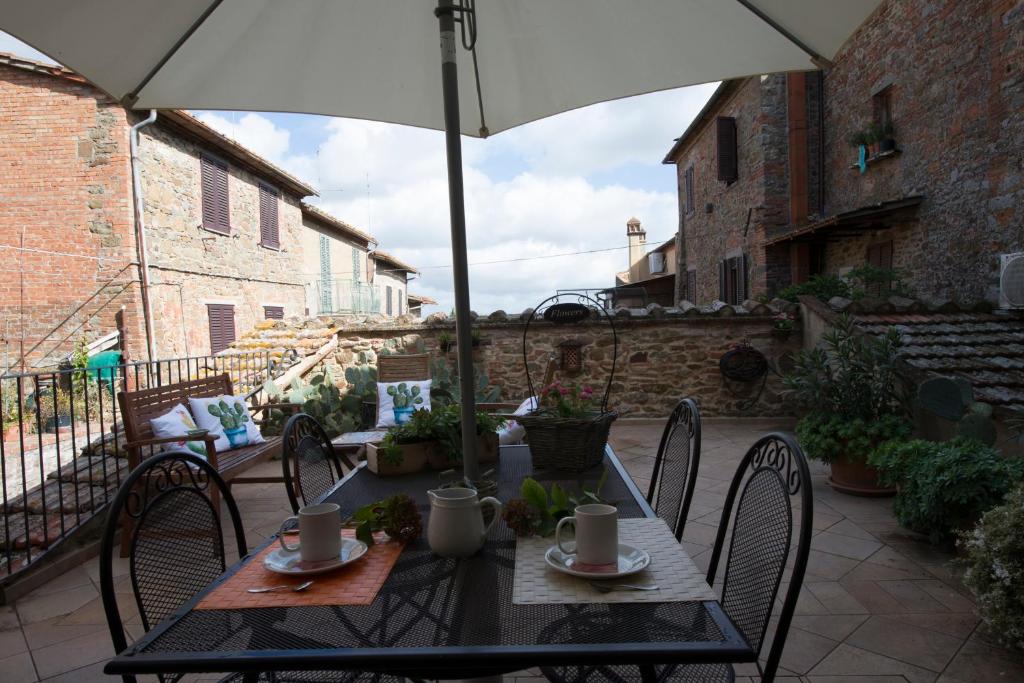 einen Tisch und Stühle mit Sonnenschirm auf einer Terrasse in der Unterkunft Casa Benoi in Rigomagno