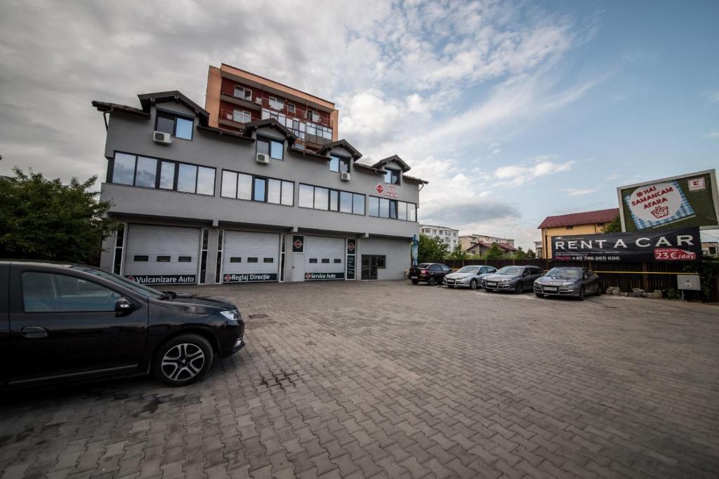 um parque de estacionamento com carros estacionados em frente a um edifício em Dr House em Mioveni