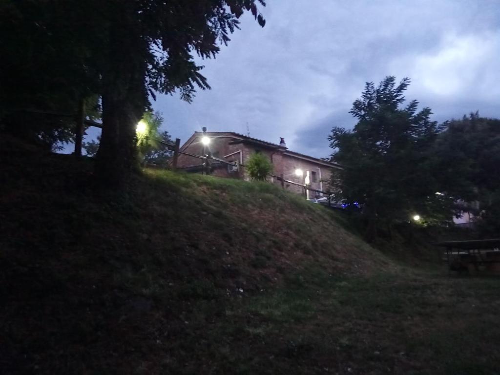 uma casa no topo de uma colina à noite em Casolare Toscano em Lorenzana