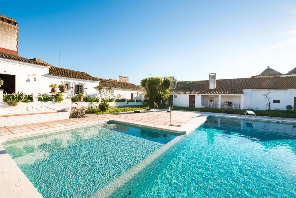 a swimming pool in front of a house at Monte das Oliveiras in Arraiolos