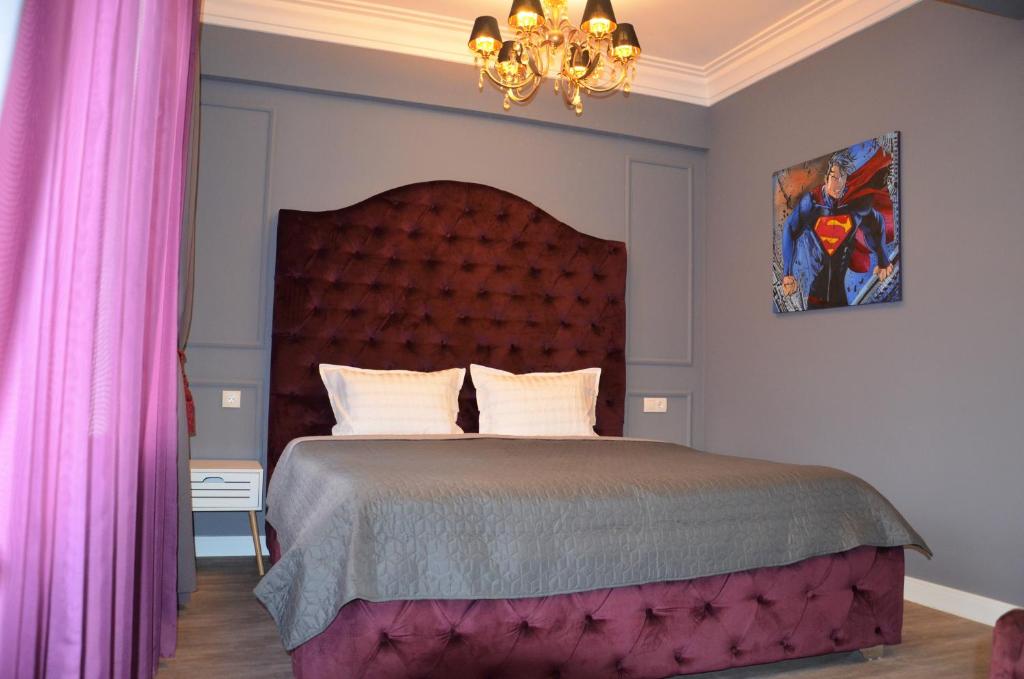 a bedroom with a bed with pink curtains and a chandelier at Kiev City Center in Kyiv