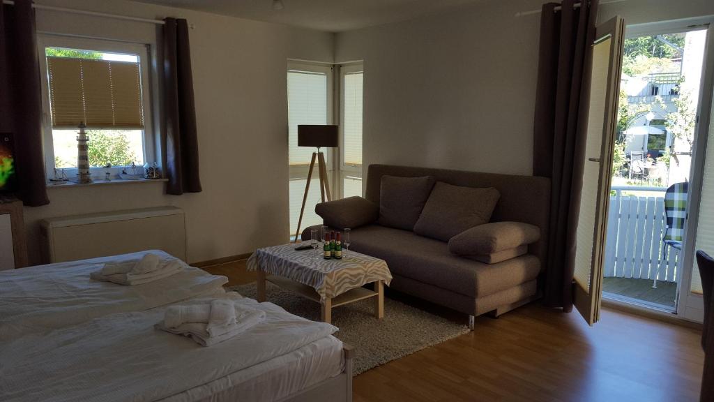 ein Schlafzimmer mit einem Bett, einem Sofa und einem Stuhl in der Unterkunft Villa Monika in Sassnitz