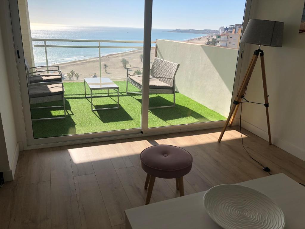 a room with a balcony with a view of the beach at Nautico Beach & Golf Alicante in Alicante