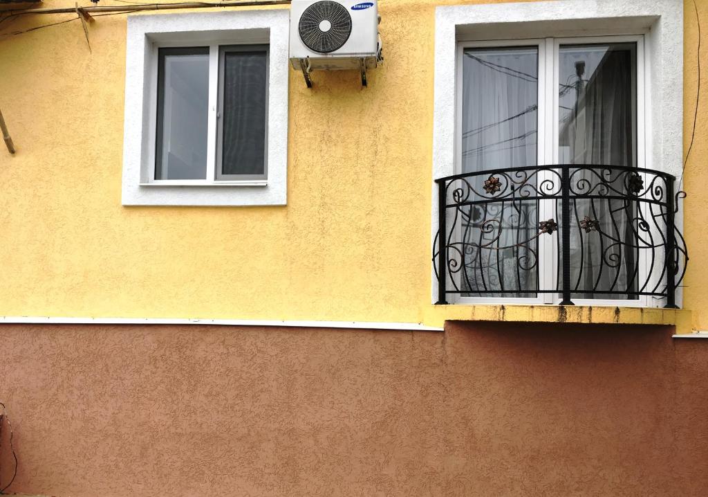 уютная студия в Резине في Rezina: مبنى أصفر مع شرفة ونافذة