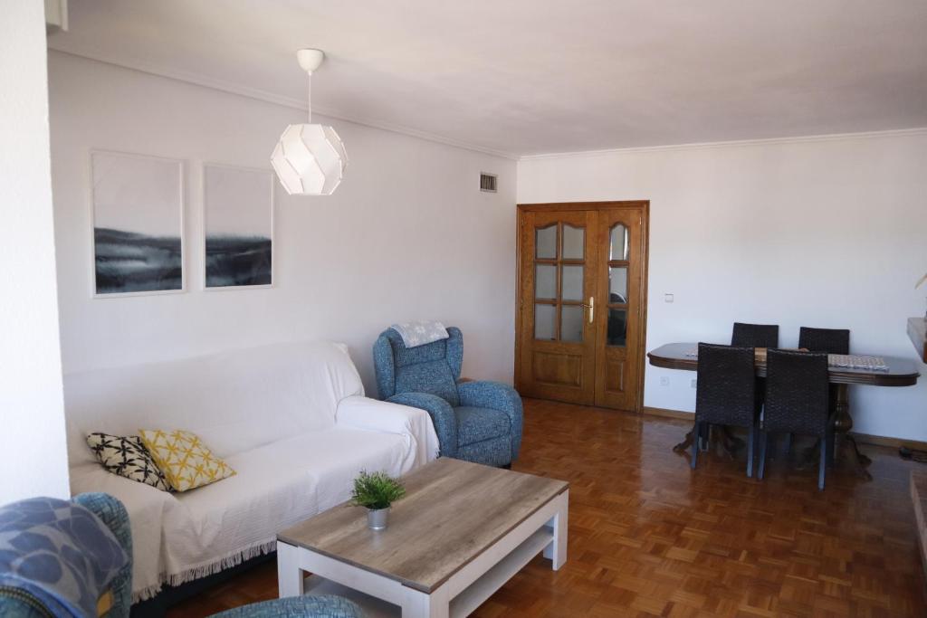 a living room with a white couch and a table at Apartamento Vega in Jaca