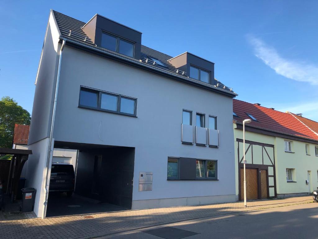 a white building with a garage at Ferienwohnung Lilie in Mittelhausen