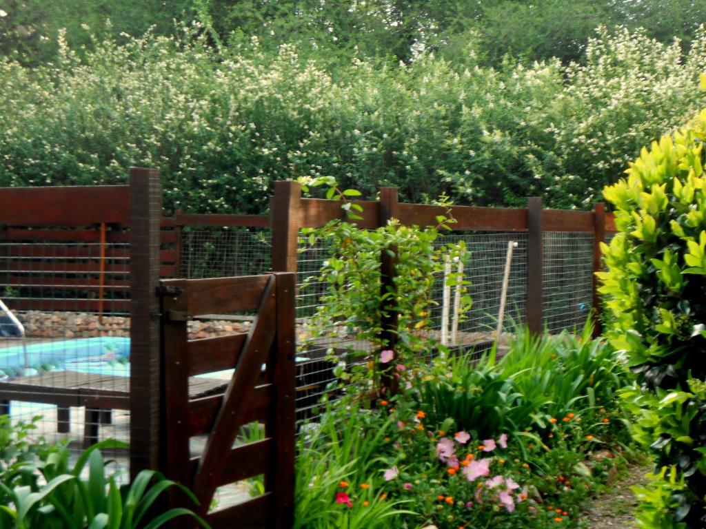 un jardín con una valla de madera y flores en Complejo Caramelo en Villa Ventana