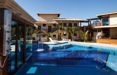 a large swimming pool in front of a building at Estrada Real Palace Hotel in Brumadinho