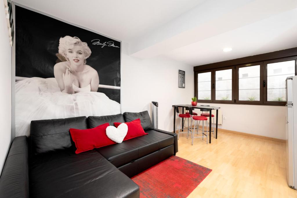 a living room with a black couch and a bed at Apartamento Supercentrico in Oviedo