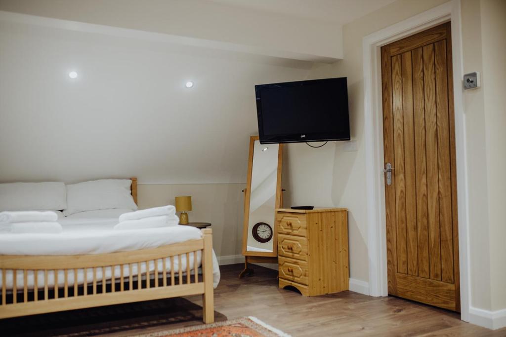 a bedroom with a bed and a flat screen tv at Betty's Loft in Lisburn