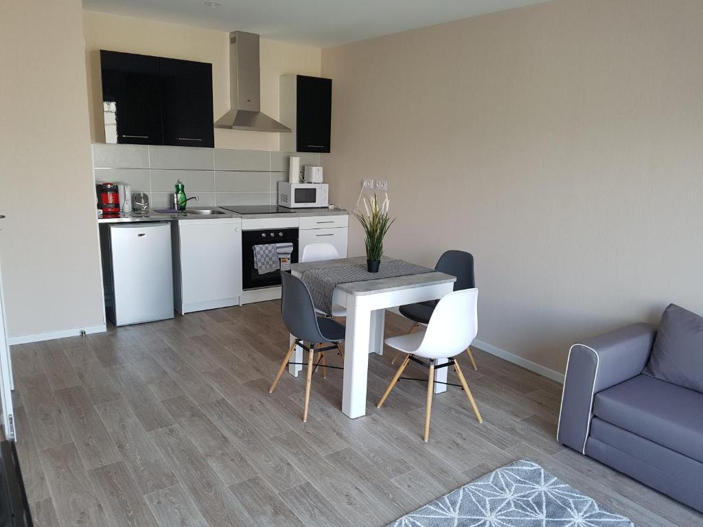 a living room with a table and chairs and a couch at Appart Neuf proche strasbourg centre et parlement européen avec PARKING in Bischheim