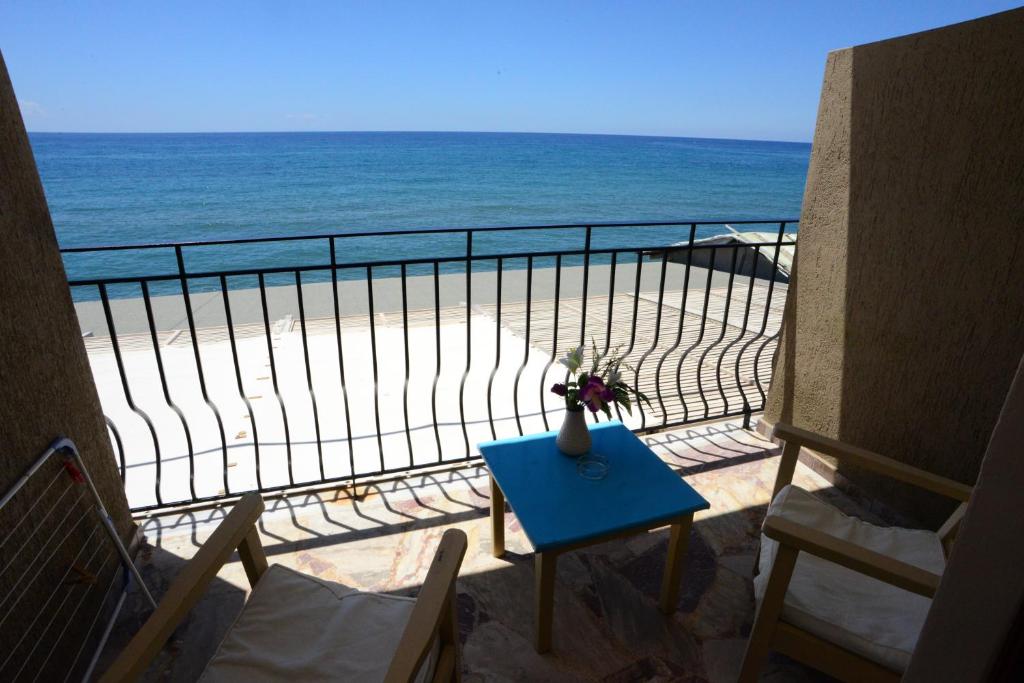a view of the beach from a balcony with a table at Sappho Hotel in Skala Eresou