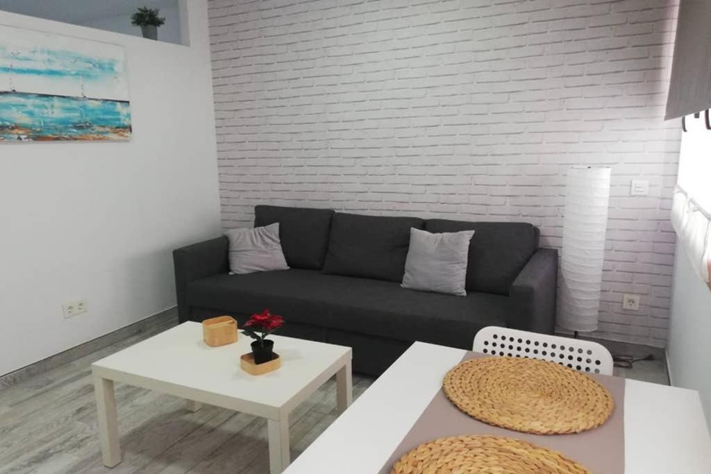 sala de estar con sofá y mesa en Apartamento Acuario en Arinaga
