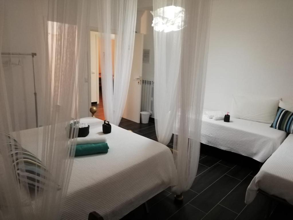 um quarto com 2 camas e cortinas brancas em Style di Elisabetta Notari em Borghesiana 