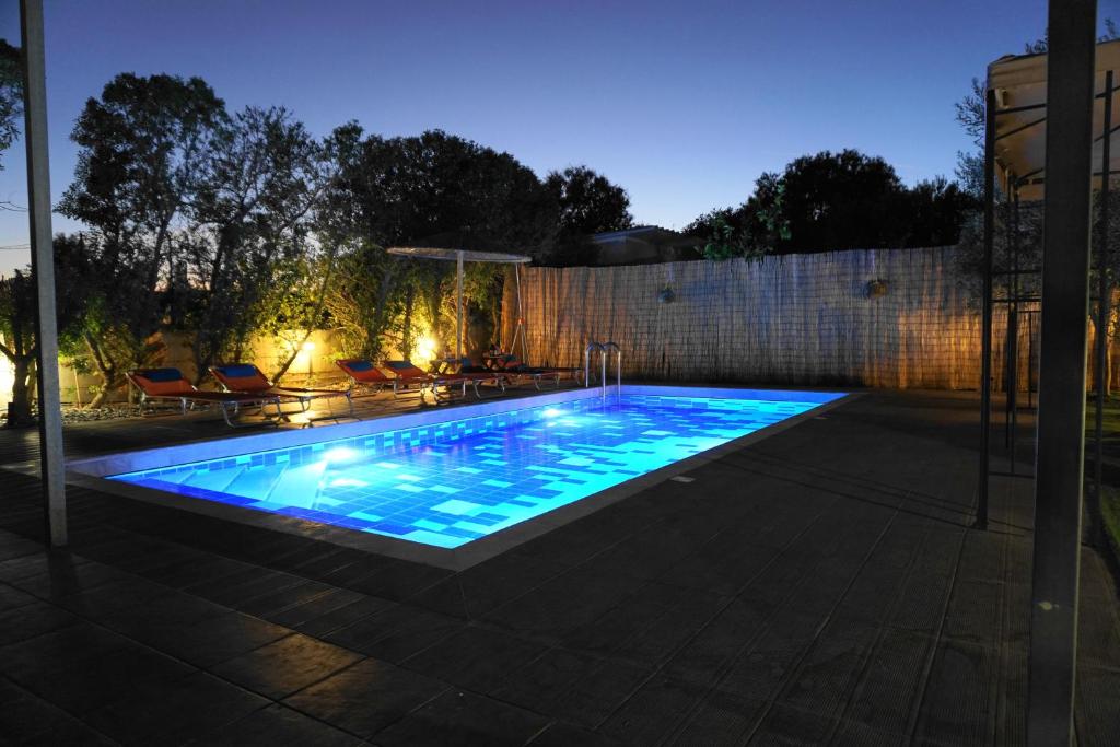 una piscina en un patio trasero por la noche en The Blue Leaf Family Villa, en Gennadi