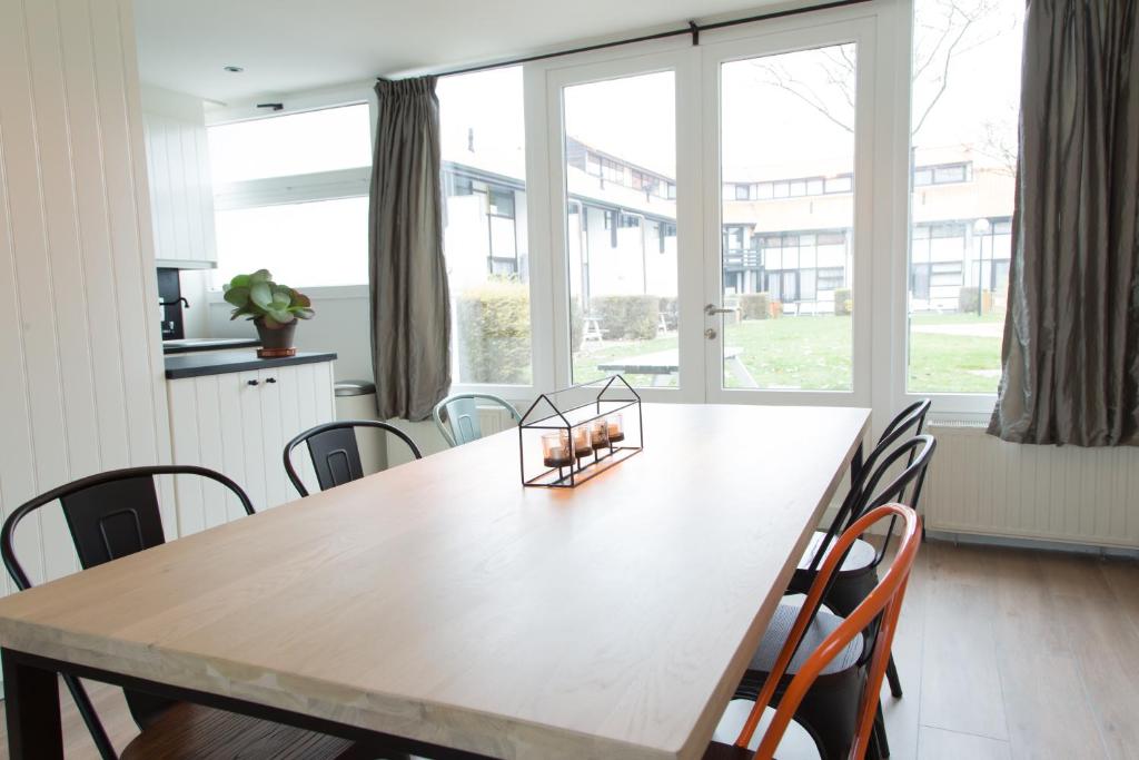 a dining room table with chairs and a large window at ESCARGOT in Middelkerke