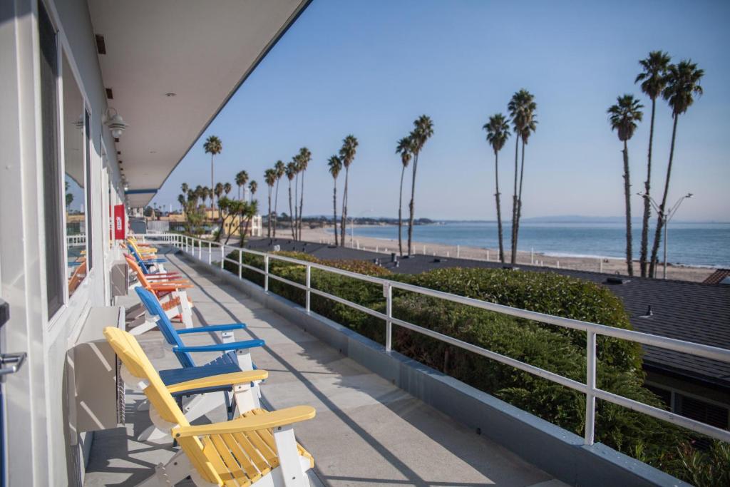 a row of chairs on a balcony overlooking the beach at Beach Street Inn and Suites in Santa Cruz