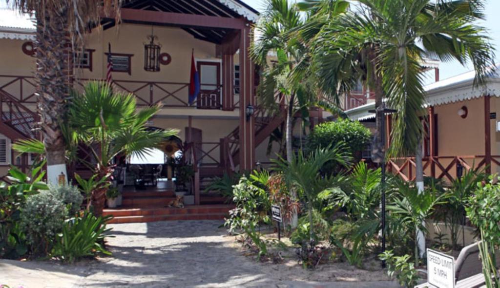 dom z palmami przed nim w obiekcie Mary's Boon Beach Plantation Resort & Spa w mieście Simpson Bay