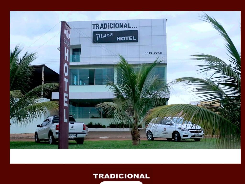 a hotel with two cars parked in front of a building at Tradicional Plaza Hotel in Nerópolis