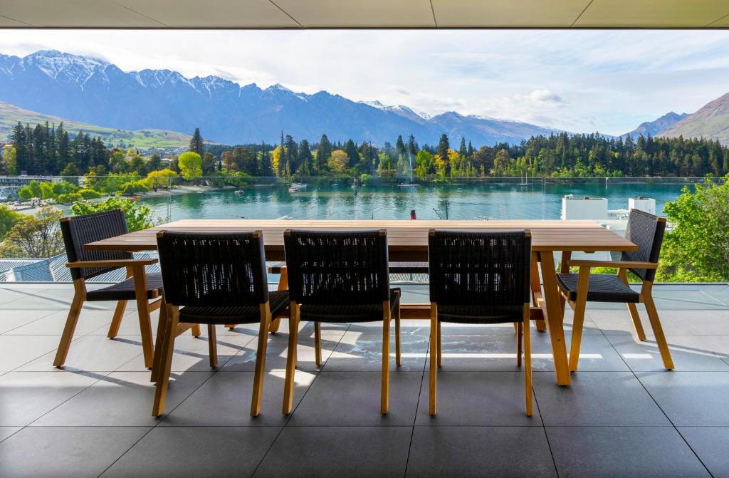 a wooden table and chairs with a view of a lake at Whakarire in Queenstown