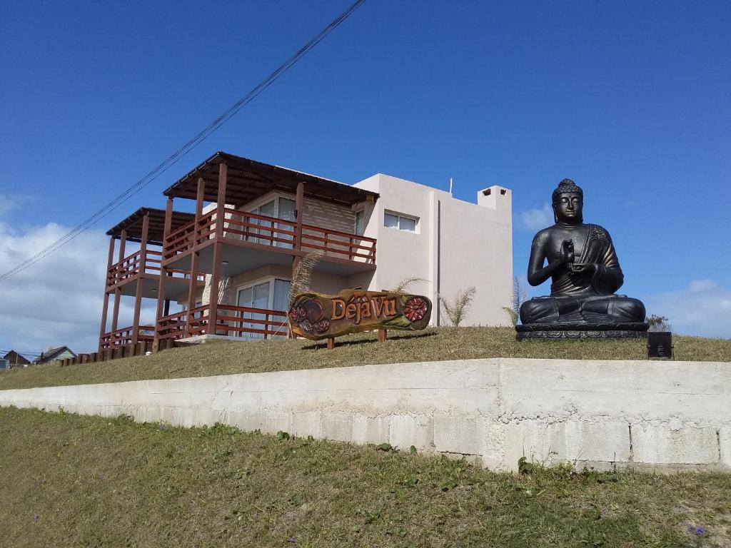 una estatua de un buddha delante de una casa en Deja Vu, en Punta del Diablo