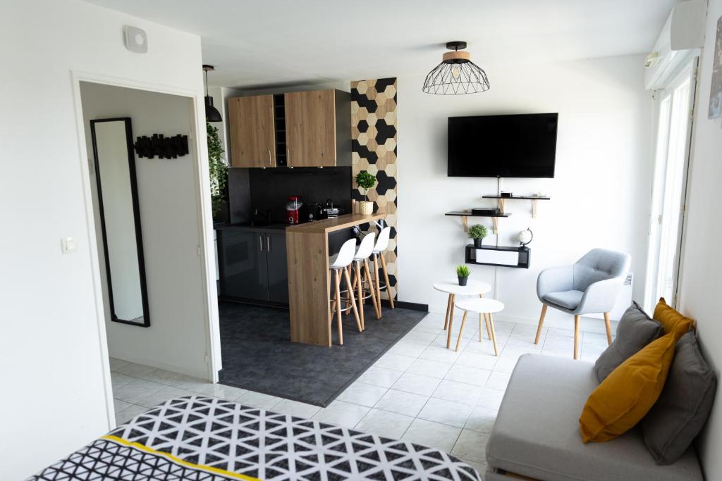 a living room with a couch and a kitchen at Sunny Studio Disneyland Paris in Montévrain