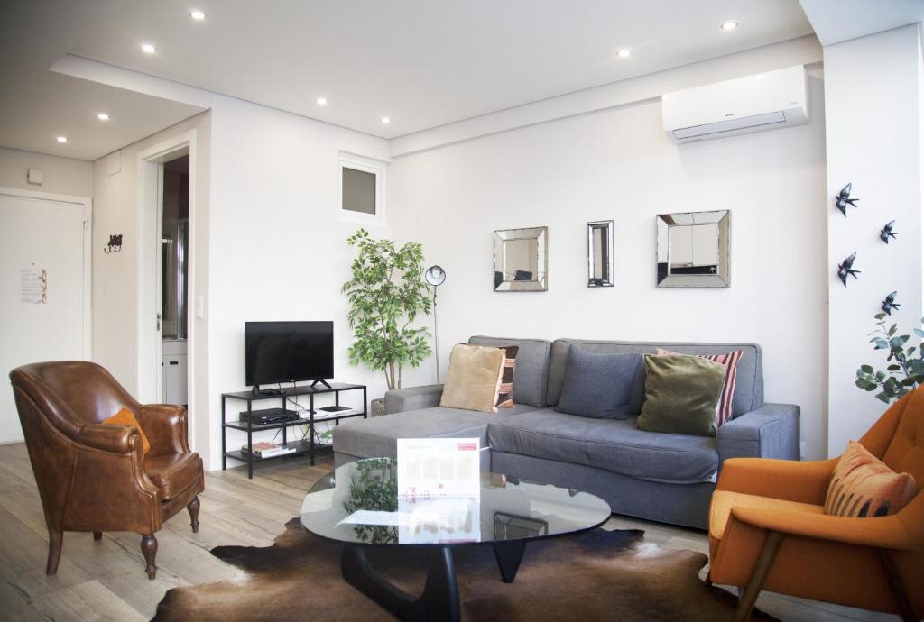 uma sala de estar com um sofá e uma mesa em FLH Campo de Ourique Bright Apartment em Lisboa