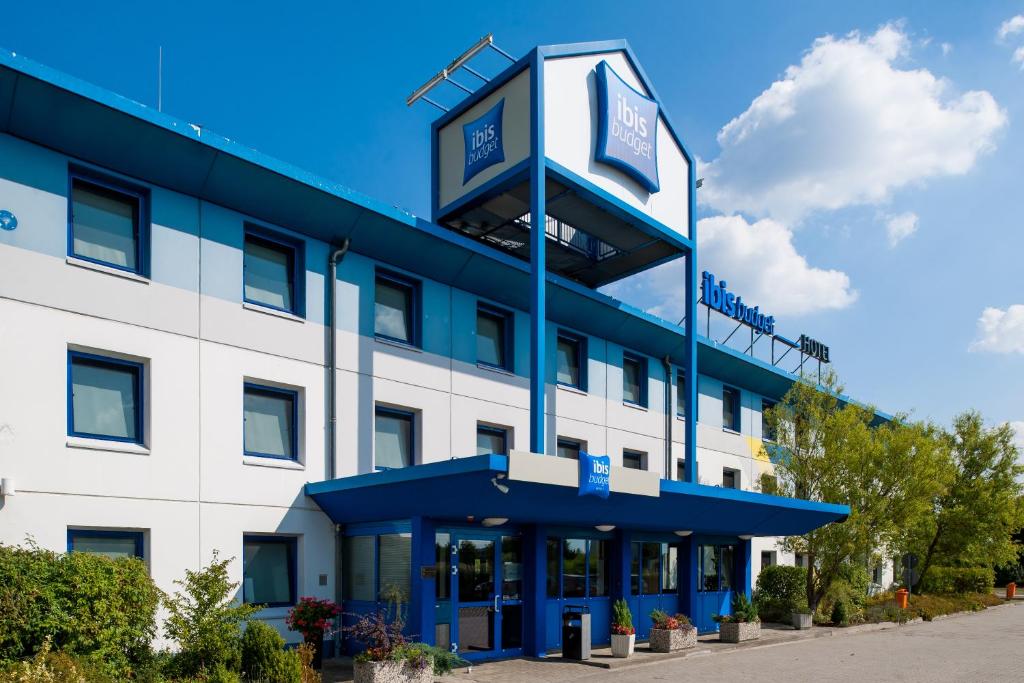 an office building with a clock tower on top at ibis budget Berlin Airport Schönefeld in Schönefeld