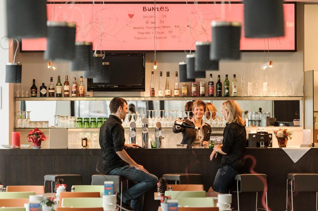 a man and a woman sitting at a bar at arte Hotel Krems in Krems an der Donau