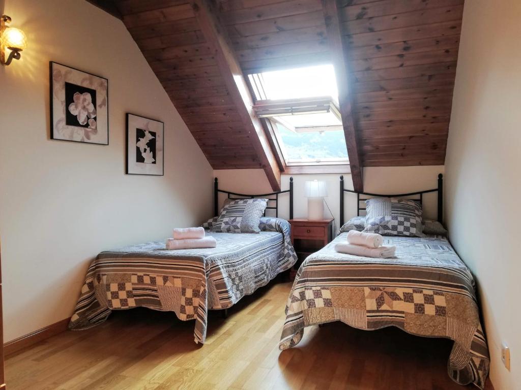 um quarto com 2 camas num sótão em Apartament Ca de Gallisca em Pla de l'Ermita
