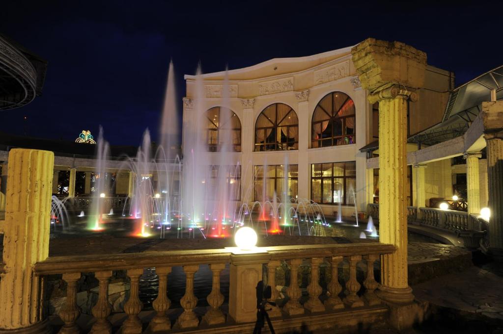 uma fonte em frente a um edifício à noite em Fontan em Chornomorsk