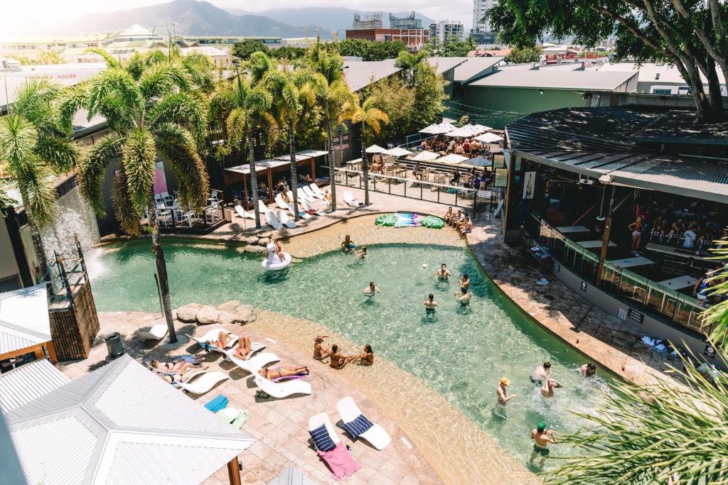 uma vista superior de uma piscina com pessoas na água em Gilligan's Hotel & Resort Cairns em Cairns