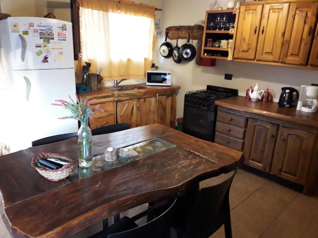 cocina con mesa de madera y nevera en Alquilo Casa Mar del Plata, Los Acantilados en Mar del Plata