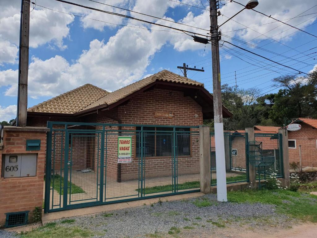 a building with a gate in front of it at Chalé Sonho Meu in Monte Verde