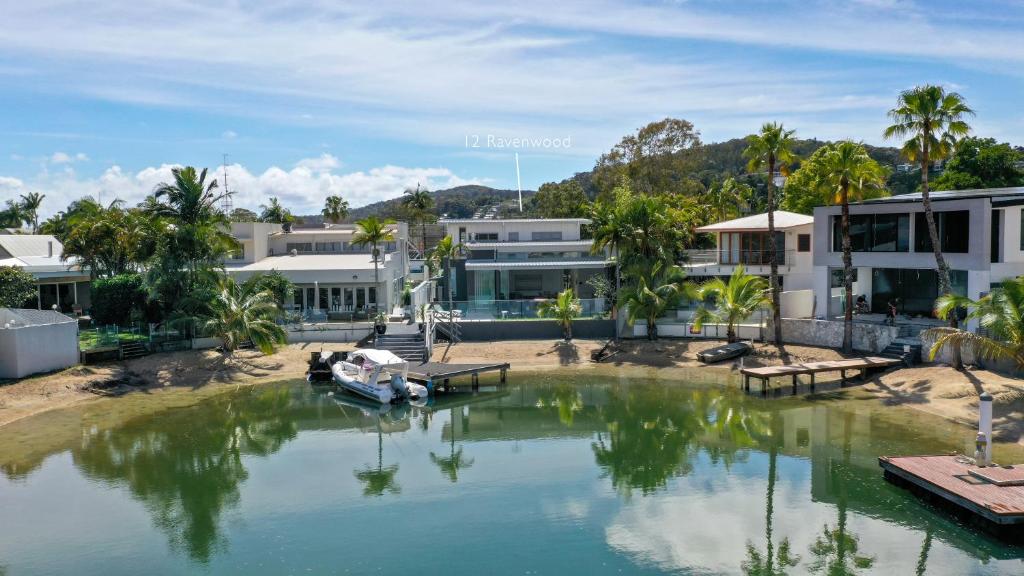 un barco en el agua frente a los edificios en Go with the flow, Noosa Sound, en Noosa Heads