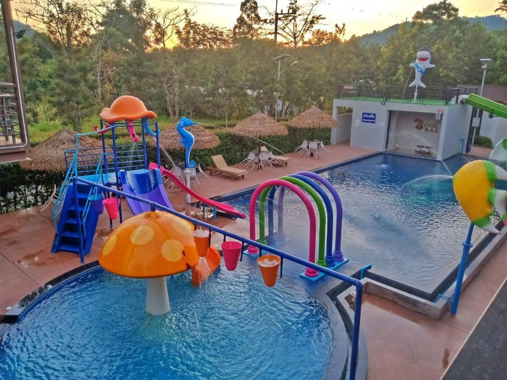 una piscina con un tobogán de agua y un parque infantil en The Rabbit Home, en Nakhon Nayok