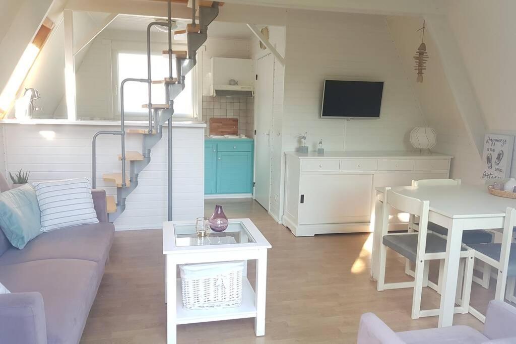 een woonkamer met een bank en een tafel bij Gezellige chalet in Nieuwpoort - Opkuis al inbegrepen in de prijs in Oostduinkerke