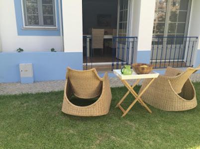 two wicker chairs and a table in a yard at Casa de férias na Praia Verde Casa de Charme in Castro Marim