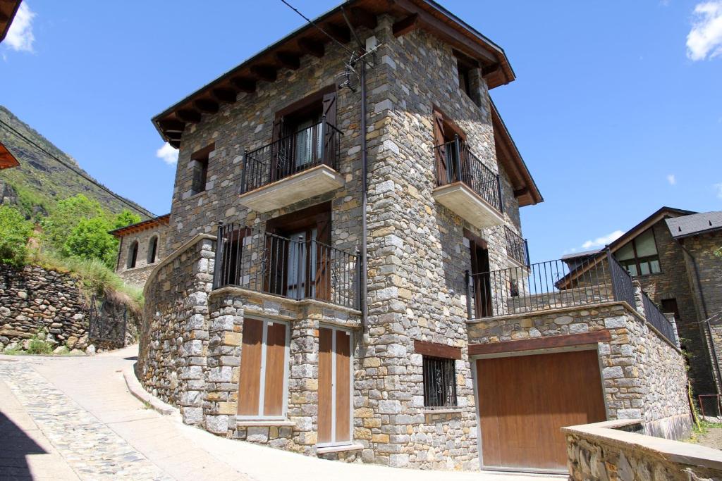a stone building with a gate and a garage at Casa Los Huertos in Sahun