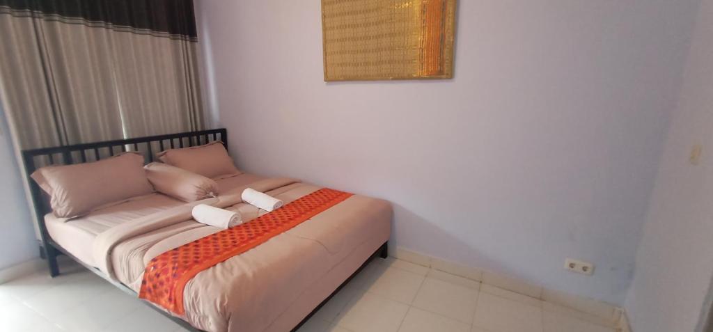 um quarto com uma cama com duas almofadas em Elisa Homestay Areguling em Kuta