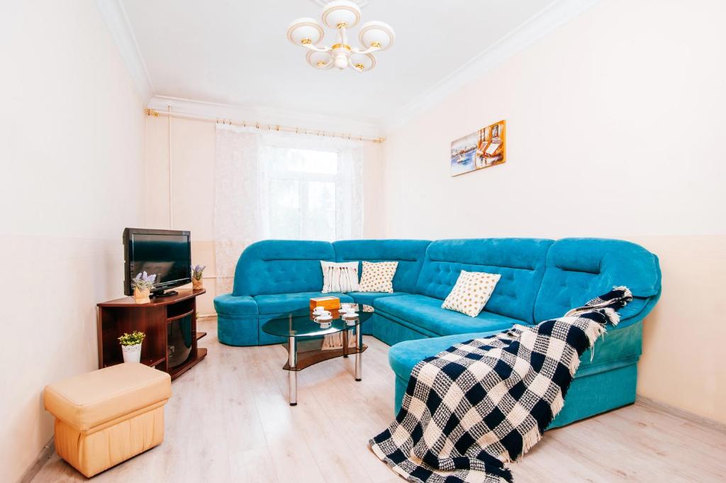 sala de estar con sofá azul y mesa en 33 Apartments, en Minsk