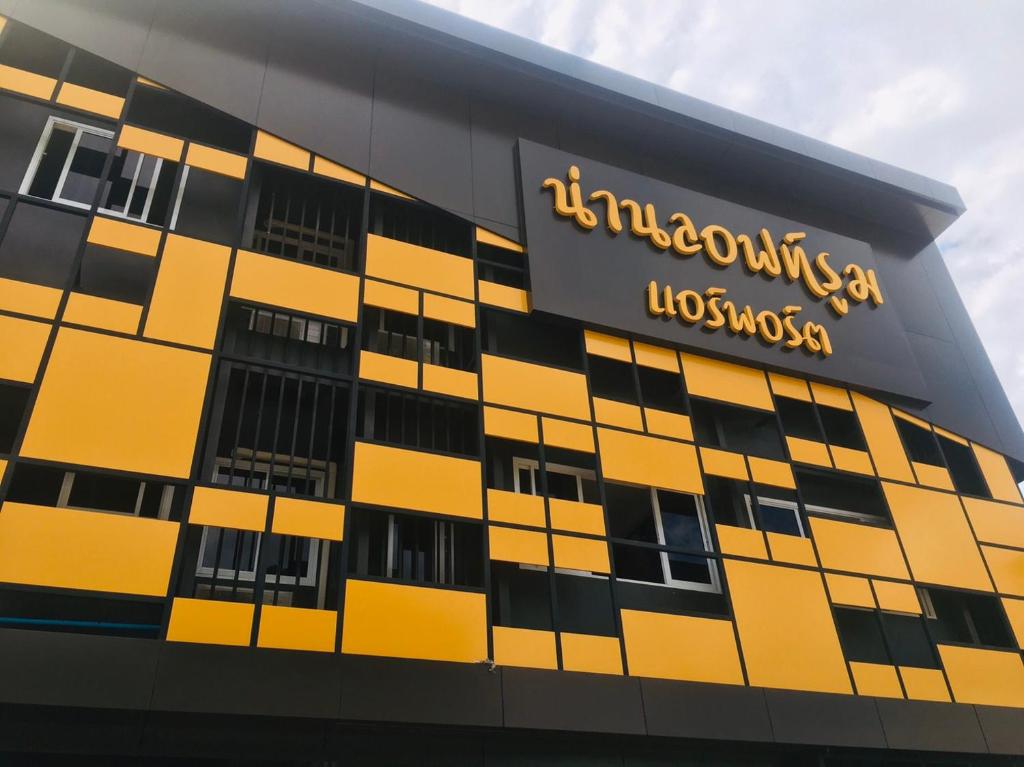 een geel en zwart gebouw met een bord erop bij น่านลอฟท์รูมแอร์พอร์ต in Nan
