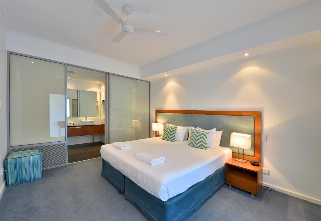 a bedroom with a large bed and a bathroom at Sea Side 110 in Mandurah