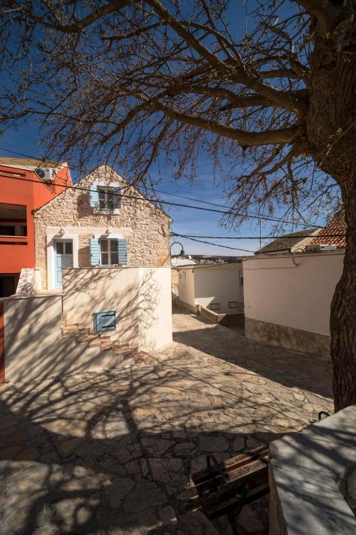 a tree in front of a house with a building at Mulberry Stonehouse in Primošten