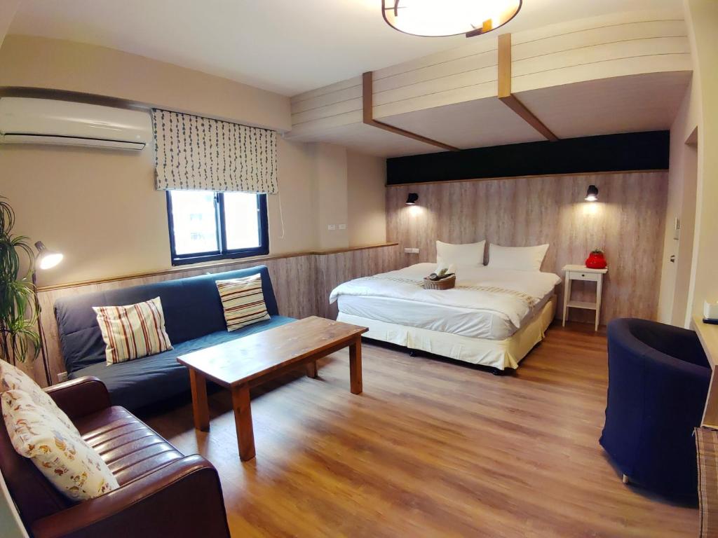 a hotel room with a bed and a couch at Hejia B&amp;B in Hualien City