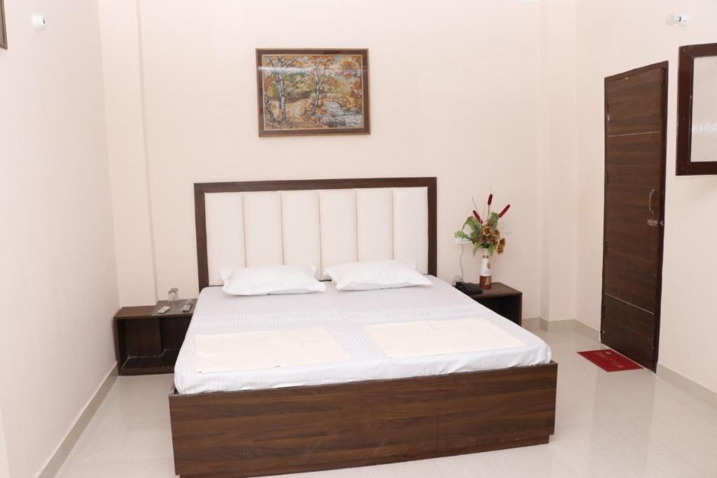 a bedroom with a large bed with white sheets at Vikas Home Stay in Amritsar