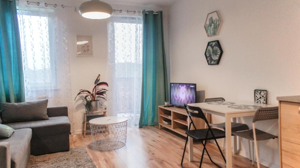 uma sala de estar com um sofá e uma mesa com cadeiras em 5 min od Dworca PKP Apartament em Lublin