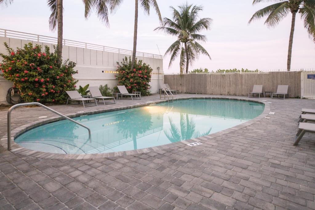basen z krzesłami i palmami w obiekcie Ocean Drive Apartments w Miami Beach