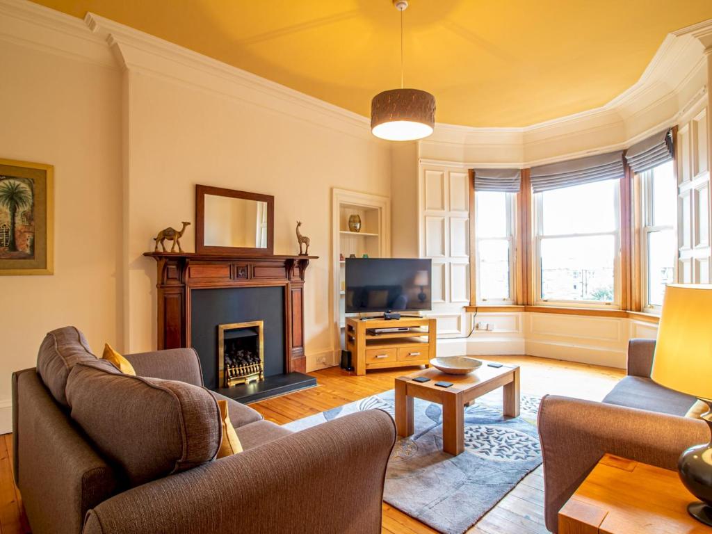 sala de estar con chimenea y TV en Pass the Keys Beautiful and Bright Georgian Style Morningside Apartment, en Edimburgo