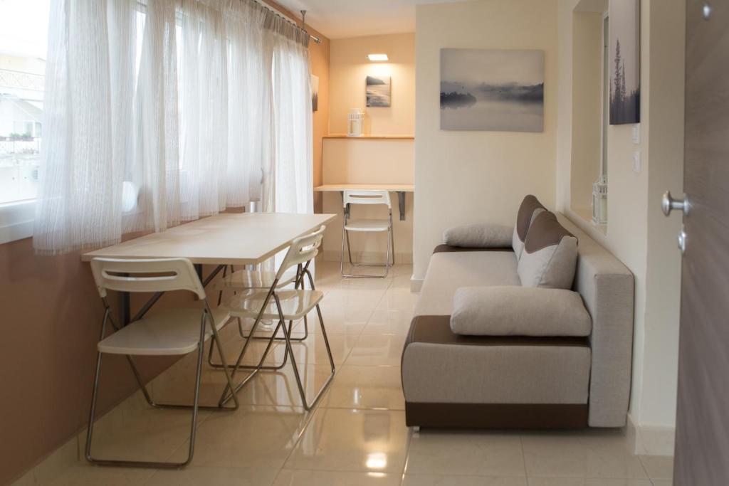 a living room with a table and a couch at Kosmos Service Apartment Modern Spirit City Center With Additional Cost Parking in Thessaloniki